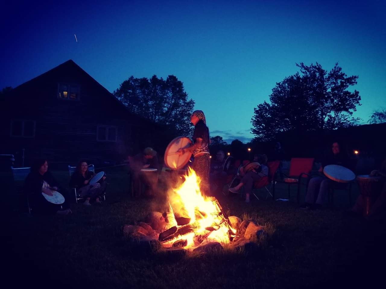 People drumming around a campfire
