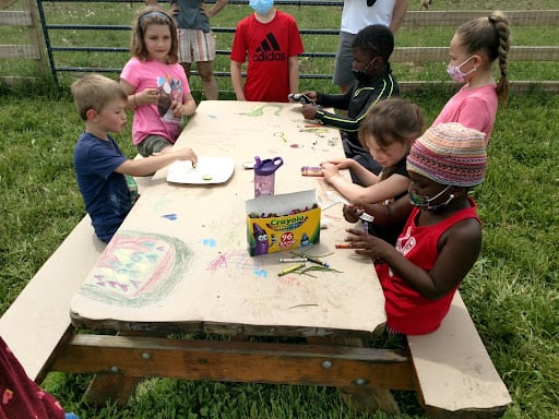 A group of kids around a table doing art at Indraloka Animal Sanctuary
